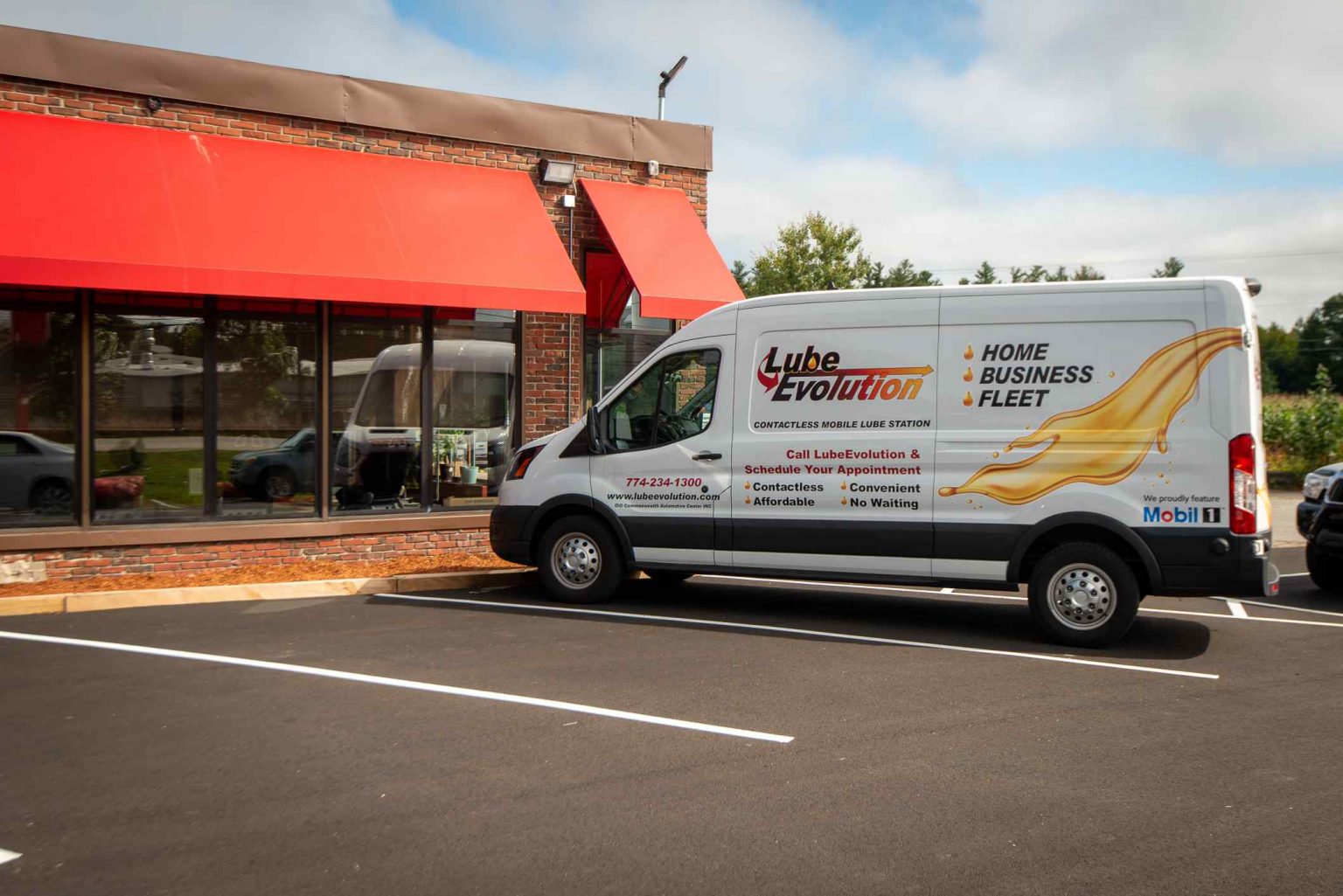 A white van parked in front of a building.