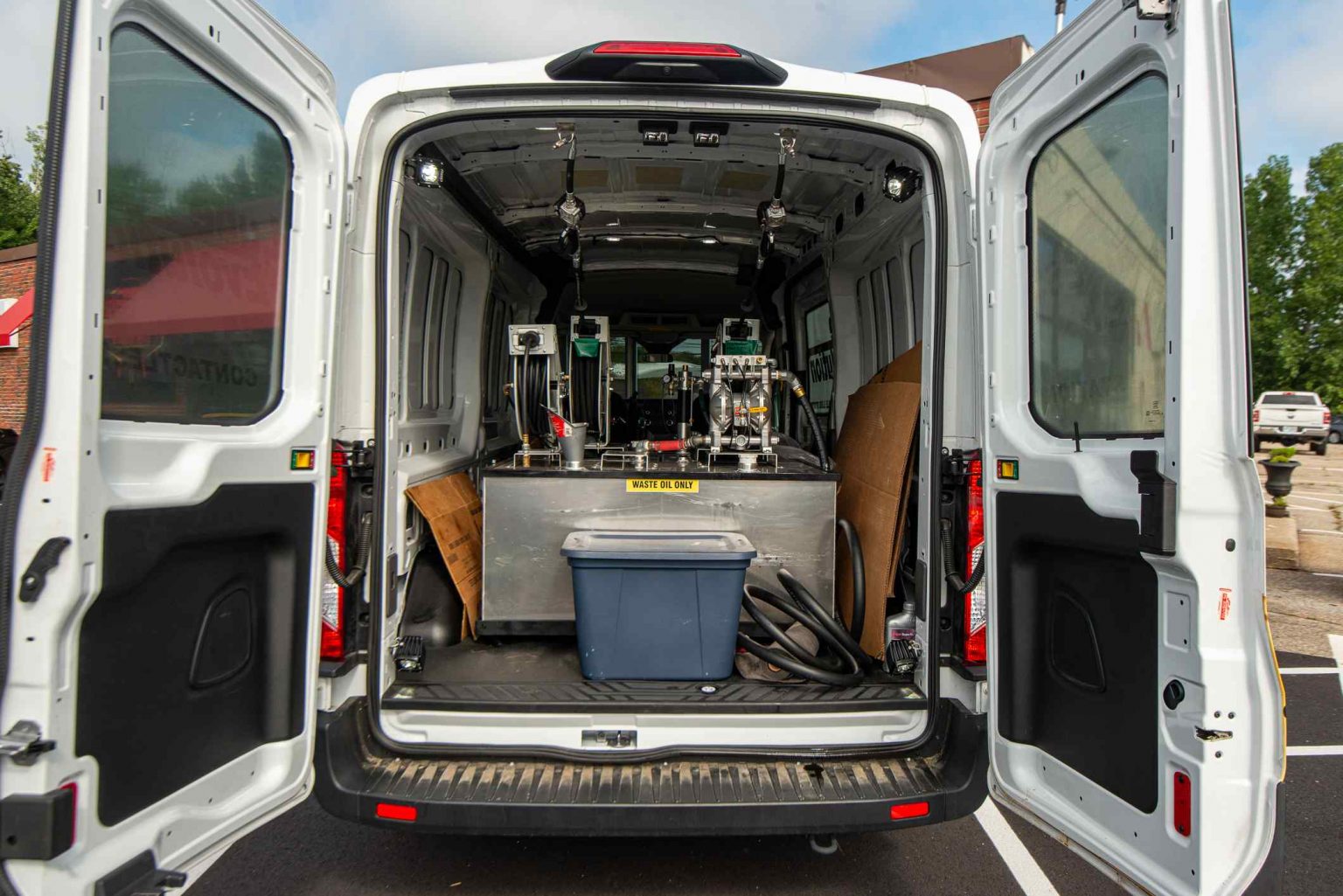 A van with the back door open and the rear seats folded down.