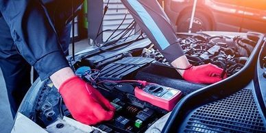 A person is working on the car battery.