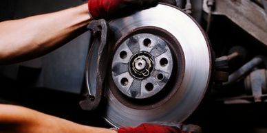 A person holding onto the brake disc of their car