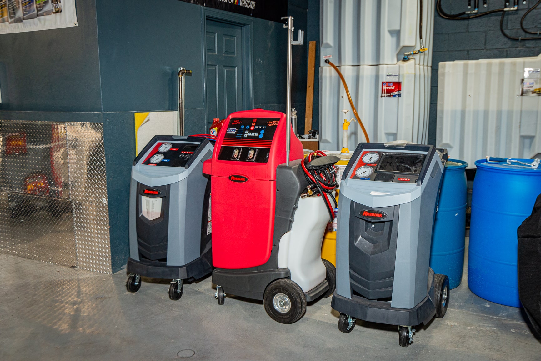 Three different types of air conditioners are sitting in a garage.